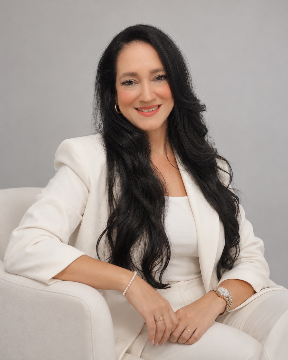 Retrato de Creusa Rodrigues sentada em uma poltrona clara, sorrindo